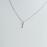 Silver necklace with a small pendant on a light gray background