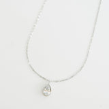 Silver necklace with a teardrop-shaped pendant on a white background