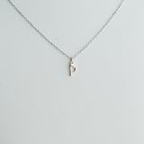 Silver necklace with a small pendant on a light gray background