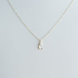 Delicate gold crescent moon necklace on a light gray background