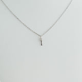 Silver necklace with a small pendant on a light gray background