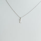 Silver necklace with a small pendant on a light gray background