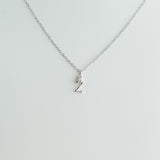 Silver necklace with a small pendant on a light gray background