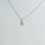 Silver necklace with a small pendant on a light gray background
