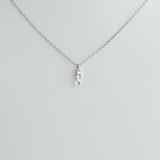 Silver necklace with a small pendant on a light gray background