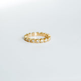 Gold ring with small diamonds on a light gray background