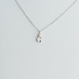 Silver necklace with a small pendant on a light gray background