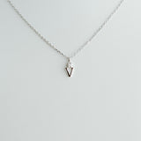 Silver necklace with a small pendant on a light gray background