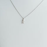 Silver necklace with a small pendant on a light gray background