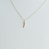 Gold necklace with a small pendant on a light gray background