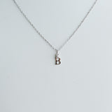 Silver necklace with a small pendant on a light gray background