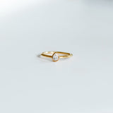 Gold ring with a small gemstone on a light gray background