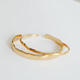 Gold hoop earrings on a light gray background