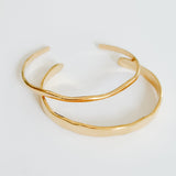 Gold bracelet on a light gray background