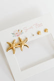 Gold starfish earrings on a white card with 'Sweet Three' branding.