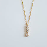 Gold necklace with a pendant on a light gray background