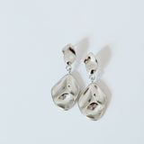 Pair of silver earrings on a light gray background