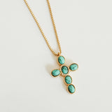 Gold necklace with turquoise stones on a light gray background