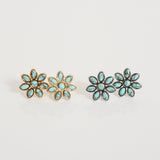 Pair of flower-shaped earrings with turquoise stones on a light gray background